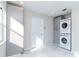 Bright laundry room with grey cabinets and stacked washer and dryer at 9376 French Quarters Cir, Weeki Wachee, FL 34613