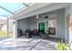 Covered patio with outdoor seating, ceiling fan, and sliding glass doors leading to living room at 9376 French Quarters Cir, Weeki Wachee, FL 34613