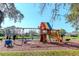 Community playground with a wooden playset, swings, and a slide by the lake at 9376 French Quarters Cir, Weeki Wachee, FL 34613
