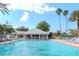 Large outdoor community pool with lounge chairs and tropical palm trees on a sunny day at 9376 French Quarters Cir, Weeki Wachee, FL 34613