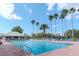Outdoor pool area with lounge chairs, palm trees, and a clear blue sky, perfect for relaxation at 9376 French Quarters Cir, Weeki Wachee, FL 34613