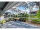 Spacious screened-in patio with lush landscaping, perfect for relaxing and enjoying the outdoors bug-free at 9376 French Quarters Cir, Weeki Wachee, FL 34613