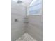 Contemporary shower showcasing a pebble floor, tiled walls and rain shower head at 9376 French Quarters Cir, Weeki Wachee, FL 34613