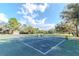 Well-maintained tennis court with a smooth playing surface and surrounded by lush greenery for sports enthusiasts at 9376 French Quarters Cir, Weeki Wachee, FL 34613