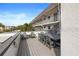 Wide-angle view of the balcony with a large outdoor dining table, chairs, and relaxing lounge chairs at 9815 47Th N Ave # 303, St Petersburg, FL 33708