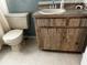 Bathroom features tile floors and vanity with natural-toned wood cabinets at 9815 47Th N Ave # 303, St Petersburg, FL 33708
