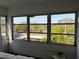 Lanai view showcasing screened windows, lush greenery, and a distant lake at 9815 47Th N Ave # 303, St Petersburg, FL 33708