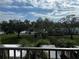 Balcony view of landscaped greenery, mature trees and cloudy skies at 9815 47Th N Ave # 303, St Petersburg, FL 33708