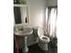 Bathroom featuring a pedestal sink, toilet, and gray tile flooring at 4905 Court St, Zephyrhills, FL 33541