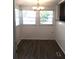 Bright dining area with large windows, modern flooring, and a stylish chandelier at 4905 Court St, Zephyrhills, FL 33541