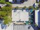Aerial view of a beach volleyball court with surrounding trees, seating, and nearby parking at 10263 Gandy N Blvd # 2014, St Petersburg, FL 33702