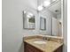 Bathroom featuring a vanity with granite countertop and a decorative mirror with a modern lighting fixture at 10263 Gandy N Blvd # 2014, St Petersburg, FL 33702