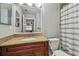 Bright bathroom with a granite vanity, large mirror, and a bathtub with a striped shower curtain at 10263 Gandy N Blvd # 2014, St Petersburg, FL 33702