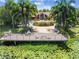 Community clubhouse with pool and patio seating overlooking a lush pond with lily pads at 10263 Gandy N Blvd # 2014, St Petersburg, FL 33702