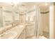 Bright bathroom with double sinks, vanity, mirror, and combination shower and bath at 14700 Gulf Blvd # 405, Madeira Beach, FL 33708