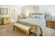 Well-lit main bedroom showcasing comfortable king bed, bench, and stylish side chair at 14700 Gulf Blvd # 405, Madeira Beach, FL 33708