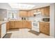 Well-lit kitchen featuring light wood cabinetry, white appliances, and ample counter space at 14700 Gulf Blvd # 405, Madeira Beach, FL 33708