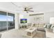 Bright living room featuring neutral tones, comfortable seating, and sliding glass doors to a balcony with ocean views at 14700 Gulf Blvd # 405, Madeira Beach, FL 33708
