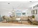 Spacious, bright living room with ocean view, modern furniture, and access to a balcony at 14700 Gulf Blvd # 405, Madeira Beach, FL 33708