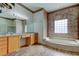 Bathroom with large vanity, jetted tub, and glass block window at 1547 Daylily Dr, Trinity, FL 34655