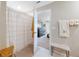 Bright bathroom featuring a patterned shower curtain, neutral walls and view to the main bedroom at 15536 Peace River Pl, Sun City Center, FL 33573