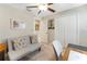 Neutral bedroom with a convertible sofa, closet, and ceiling fan, creating a functional and comfortable space at 15536 Peace River Pl, Sun City Center, FL 33573