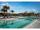 Community pool with palm trees and lots of lounge chairs for residents to enjoy the outdoors at 16936 Falling Waters Ct, Land O Lakes, FL 34638