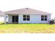 The backyard of the home has a covered patio and a lush green lawn at 17036 James Trl, Parrish, FL 34219