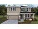 Charming two-story home featuring stone accents, a two-car garage, and well-manicured landscaping at 17065 James Trl, Parrish, FL 34219