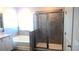 Bathroom features a soaking tub, glass shower, gray tiled walls, and granite counters at 1741 Cobb Trl, Parrish, FL 34219