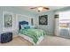 Bright bedroom featuring blue walls, carpet flooring, and a large window with lovely decor at 1741 Cobb Trl, Parrish, FL 34219