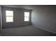 Cozy bedroom with plush carpeting and natural light streaming through two windows at 1741 Cobb Trl, Parrish, FL 34219