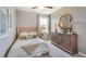 Cozy bedroom with natural lighting, textured headboard, wood dresser, and carpet floors at 1741 Cobb Trl, Parrish, FL 34219