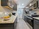 Modern kitchen with stainless steel appliances, dark cabinets, granite countertops and stylish backsplash at 179 114Th N Ave # 179, St Petersburg, FL 33716