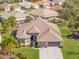 Aerial view of a single-Gathering home with mature trees, a lush green lawn, and a well-maintained roof at 182 Dahoon Ct, Spring Hill, FL 34609