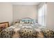 Bright bedroom featuring a large bed with a patterned comforter and decorative pillows at 182 Dahoon Ct, Spring Hill, FL 34609