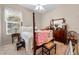 Charming bedroom with a four-poster bed, quilt, and a decorative tea set at 182 Dahoon Ct, Spring Hill, FL 34609
