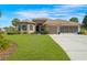 Charming home featuring a well-manicured lawn, a screened three-car garage, and attractive landscaping at 182 Dahoon Ct, Spring Hill, FL 34609