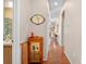 Hallway with hardwood floors featuring a vintage cabinet and views into the bathroom and other rooms at 182 Dahoon Ct, Spring Hill, FL 34609