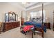 Well-lit bedroom with a four-poster bed, bench, and dresser, offering ample space and comfort at 182 Dahoon Ct, Spring Hill, FL 34609