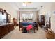 Spacious main bedroom with a four-poster bed, tray ceiling, and plenty of natural light at 182 Dahoon Ct, Spring Hill, FL 34609