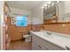 Well-lit bathroom with a large mirror and tiled walls at 19230 Lake Allen Rd, Lutz, FL 33558