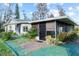 Single story home with a screened in porch and mature landscaping around the house at 19230 Lake Allen Rd, Lutz, FL 33558