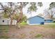 View of backyard with outbuildings and lush lawn at 20004 Harvie Ln, Lutz, FL 33558