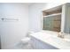 Bathroom with white toilet and vanity next to a glass shower and chrome towel bar at 20004 Harvie Ln, Lutz, FL 33558
