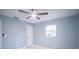 This bedroom features a ceiling fan, light blue walls, a window, and white trim at 20004 Harvie Ln, Lutz, FL 33558