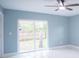 Bright bedroom features blue walls, sliding glass door to backyard and a ceiling fan at 20004 Harvie Ln, Lutz, FL 33558
