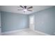 A calming bedroom features a ceiling fan, light blue walls, and marble-look tile at 20004 Harvie Ln, Lutz, FL 33558