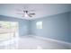 Bright bedroom with white floors, a ceiling fan, and a sliding glass door at 20004 Harvie Ln, Lutz, FL 33558