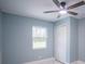 This bedroom features a window, a closet, light blue walls, and a ceiling fan at 20004 Harvie Ln, Lutz, FL 33558